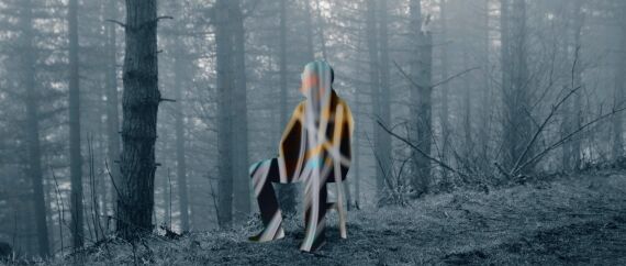 A surreal, digitally manipulated figure in a foggy forest, taken from John Smith’s "Hold On" music video, directed by RIOT.